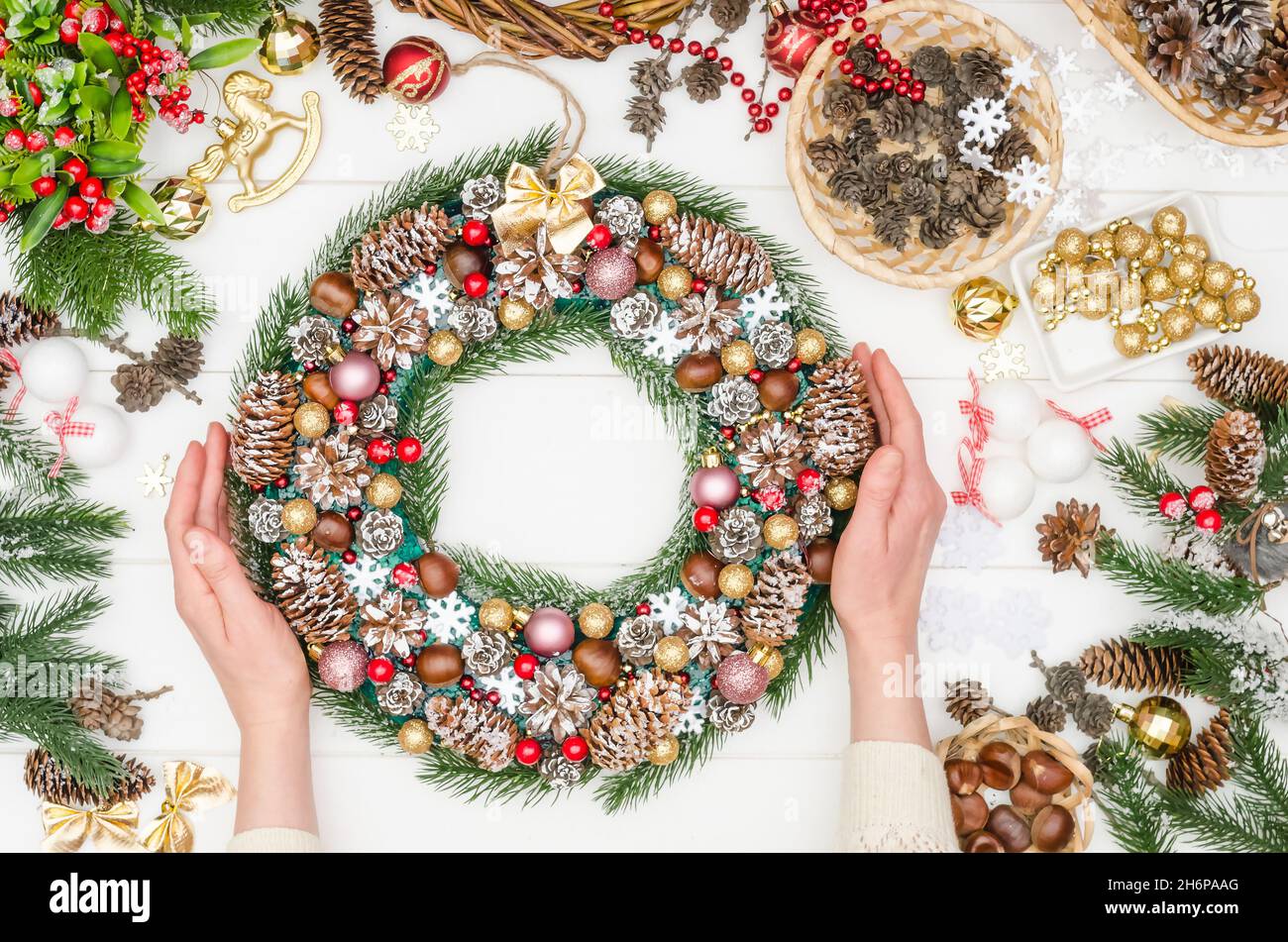 Facendo una grande corona di Natale passo dopo passo, passo 22 - una corona di Natale pronta-fatta per la decorazione domestica da coni naturali e decorazione artificiale Foto Stock