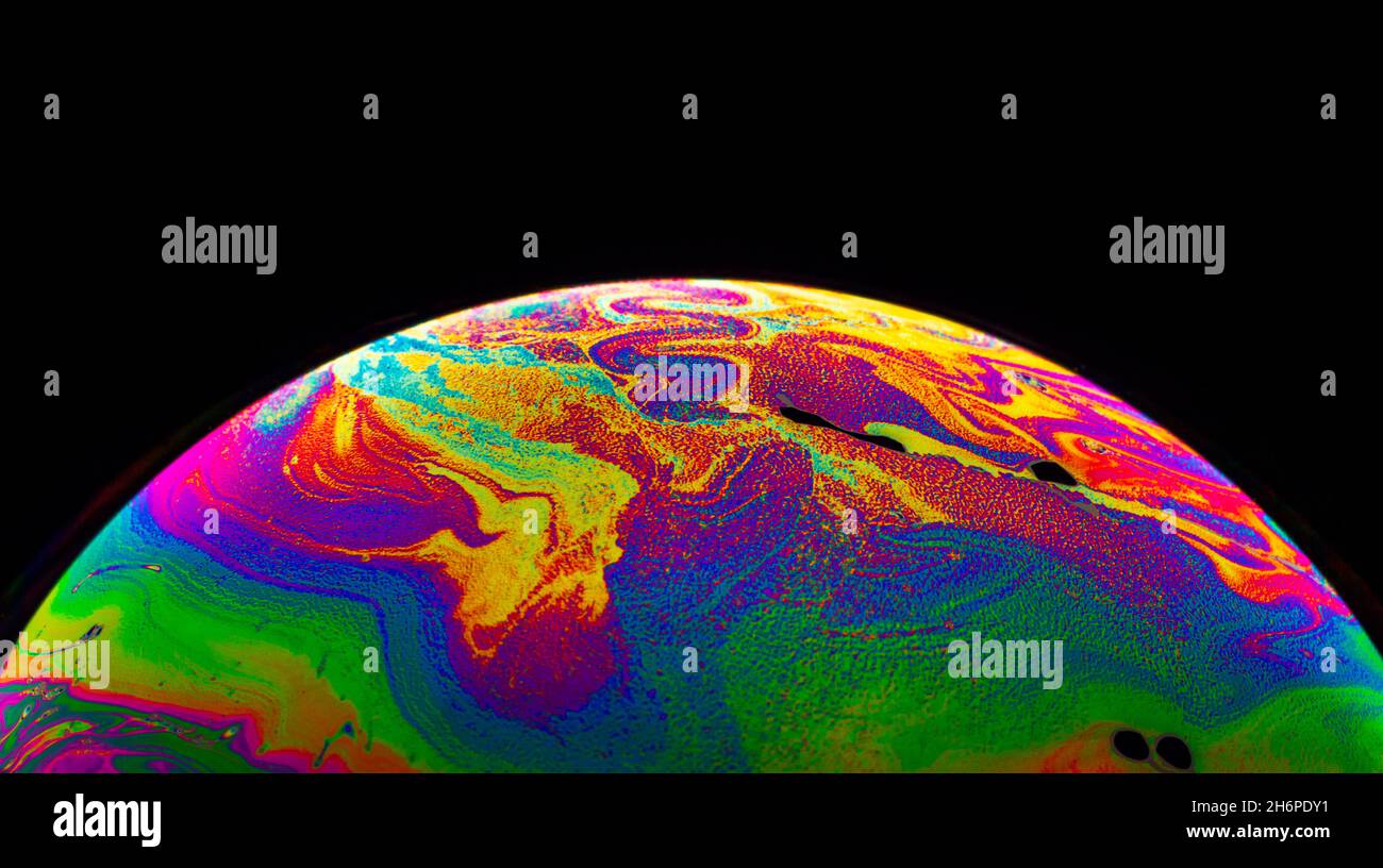 Spazio di realtà virtuale con un pianeta psichedelico astratto multicolore. Closeup bolla di sapone come un pianeta alieno su sfondo nero. Foto Stock
