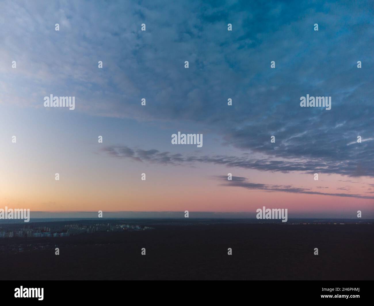 Vista aerea oscura su foresta scura al tramonto. Le pesanti nuvole blu che coprono la colorata scena del cielo serale Foto Stock
