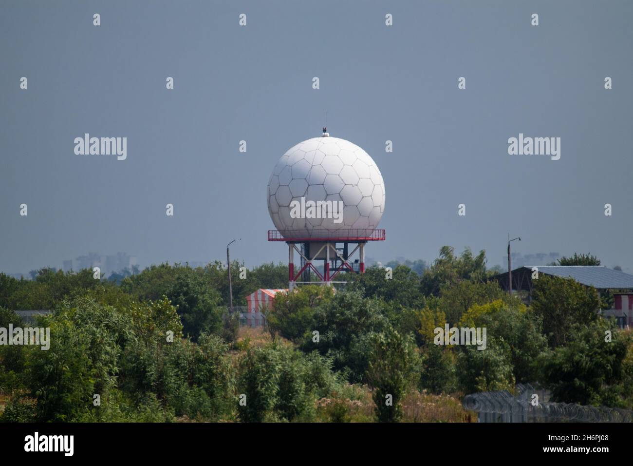 Aeroporto internazionale torre radar a sfera bianca a Kharkiv, Ucraina. Speciale radome a torre a microonde in forme esagonali nel verde nella giornata estiva soleggiata Foto Stock