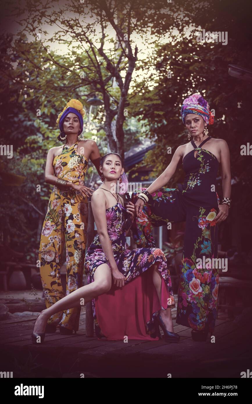BANGKOK,THAILANDIA-FEBBRAIO 19,2017: Tre di sicura bella pelle di miele tono donna in elegante abito alla moda sulla nebbia antico giardino casa w Foto Stock