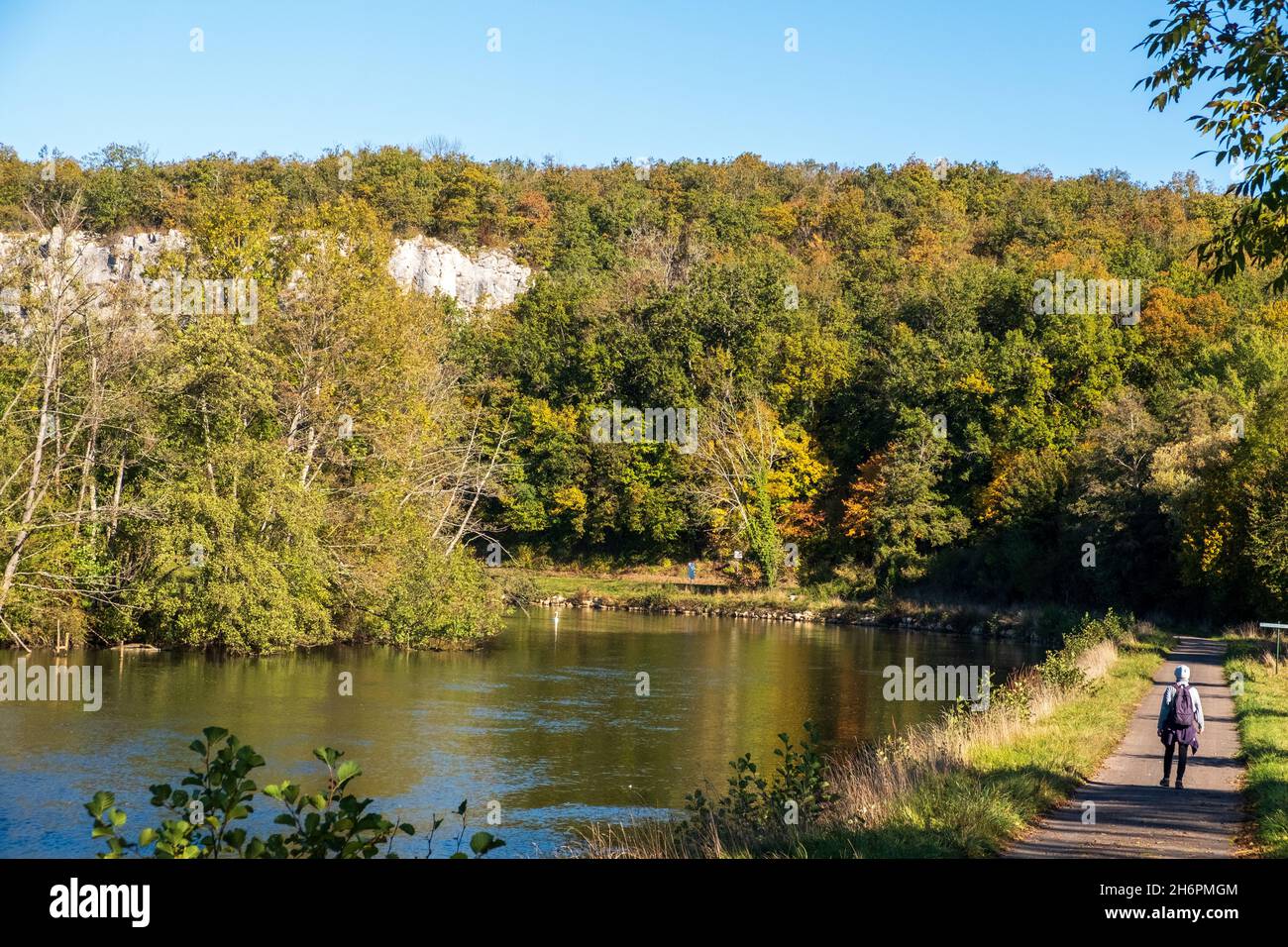 Un escursionista solista accanto al fiume Yonne (sezione Canal du Nivernais) vicino Mailly-le-Château in autunno Foto Stock