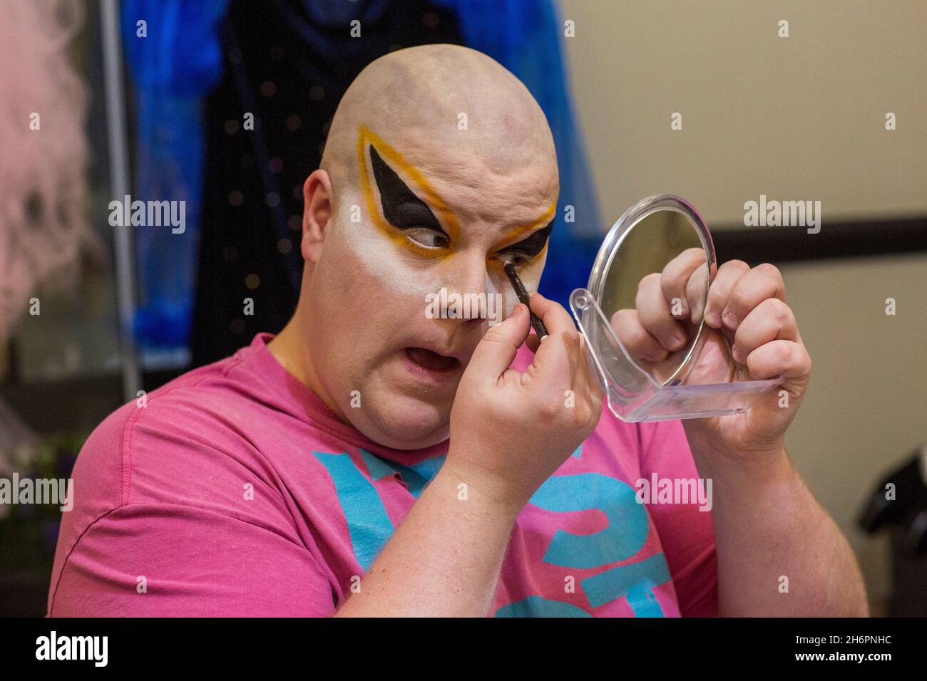 Maschio drag queen applicare drammatico make up in preparazione per una performance . Foto Stock
