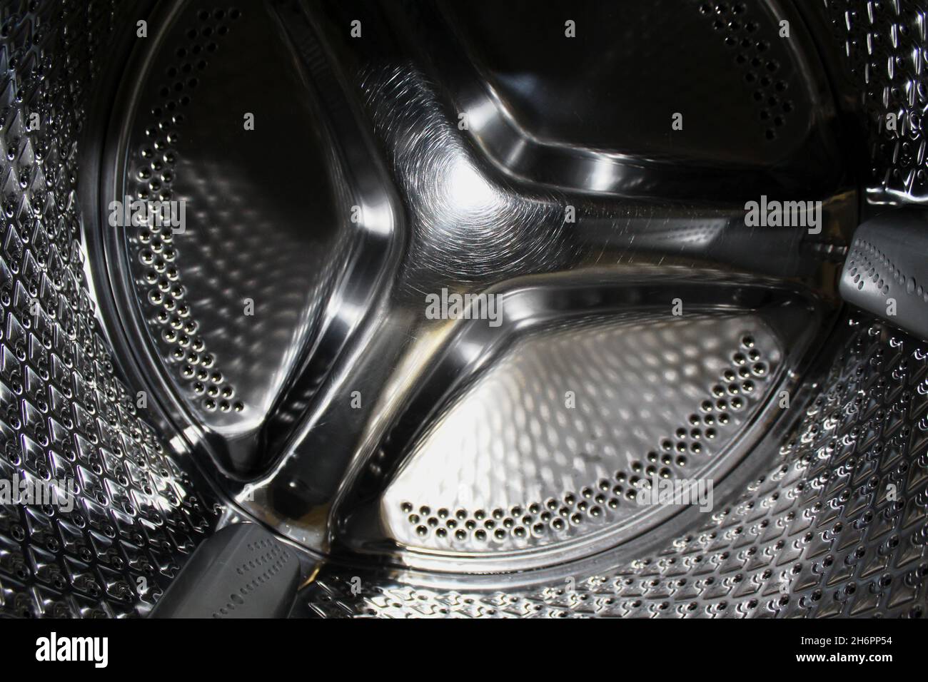 Nahaufnahme einer gelochten Waschtrommel aus Edelstahl. Foto Stock