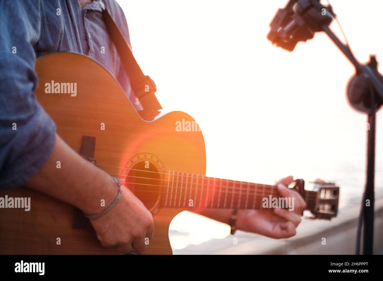 Primo piano di un uomo che suona la chitarra classica al tramonto. Foto Stock