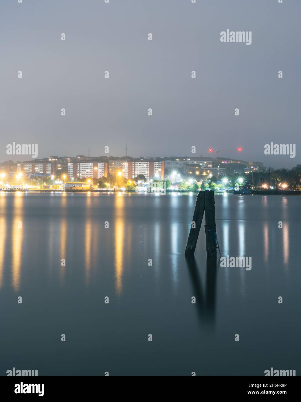 Palo di legno davanti al paesaggio urbano Foto Stock