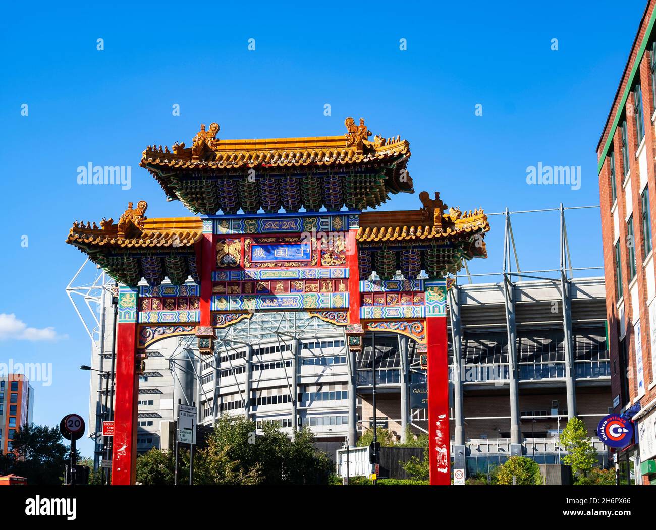 Chinatown Gate a Newcastle upon Tyne, con St. James' Park (lo stadio del Newcastle United FC) sullo sfondo Foto Stock
