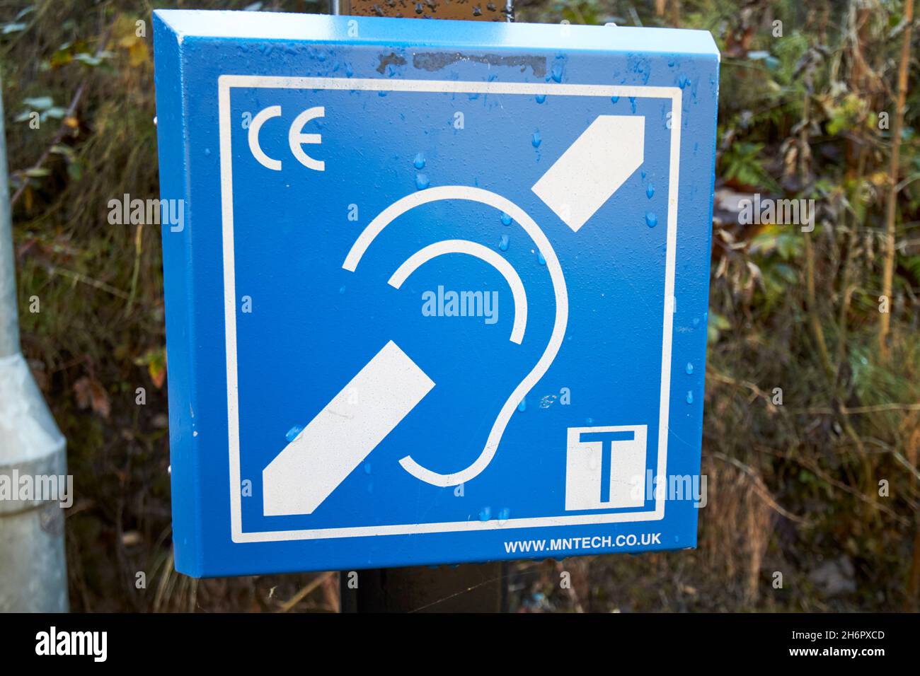 Cartello blu di induzione del circuito uditivo su una piattaforma ferroviaria Liverpool merseyside uk Foto Stock