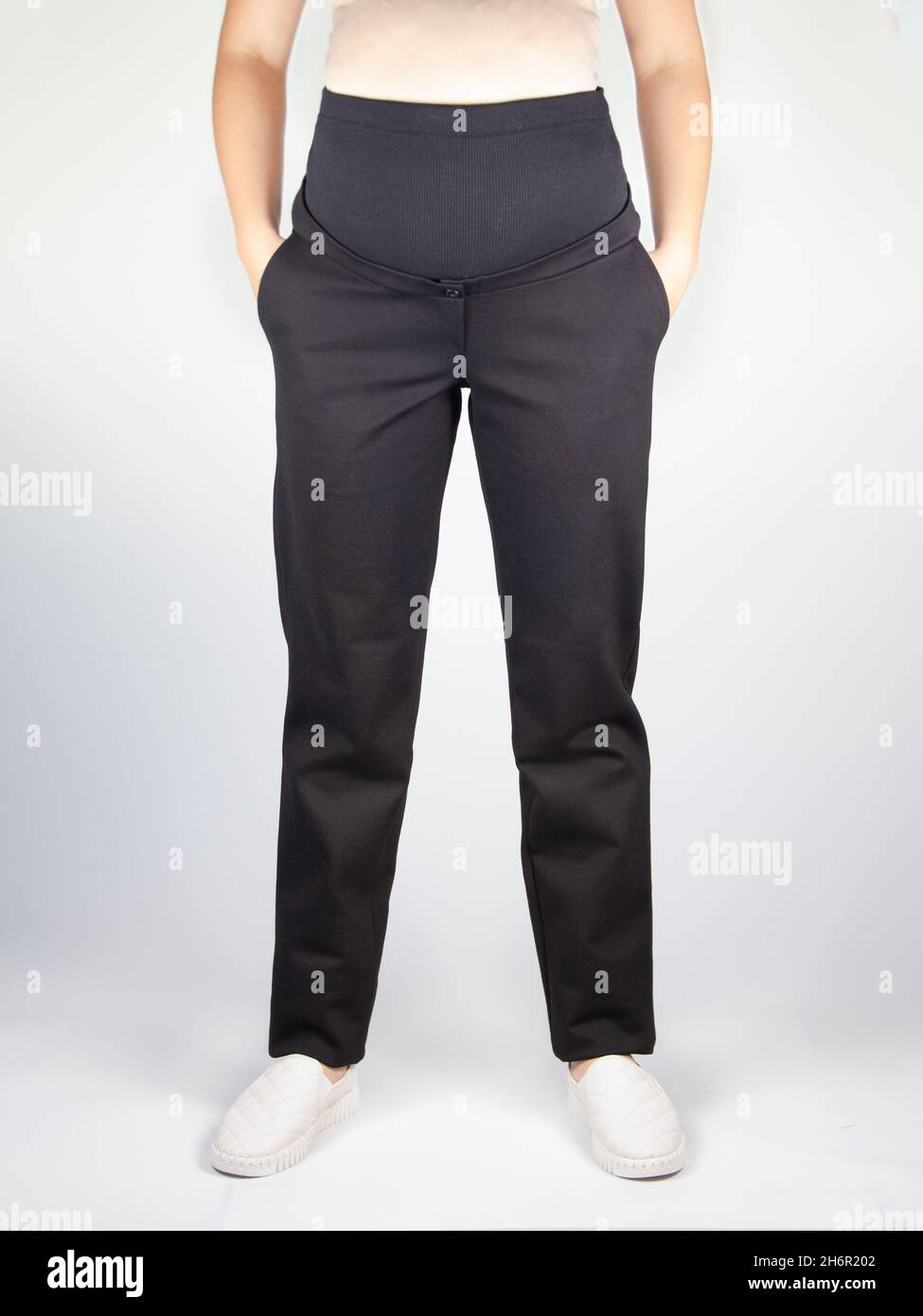 Abbigliamento per pantaloni incinta, nero con vita alta isolato su sfondo  bianco, concetto di gravidanza Foto stock - Alamy