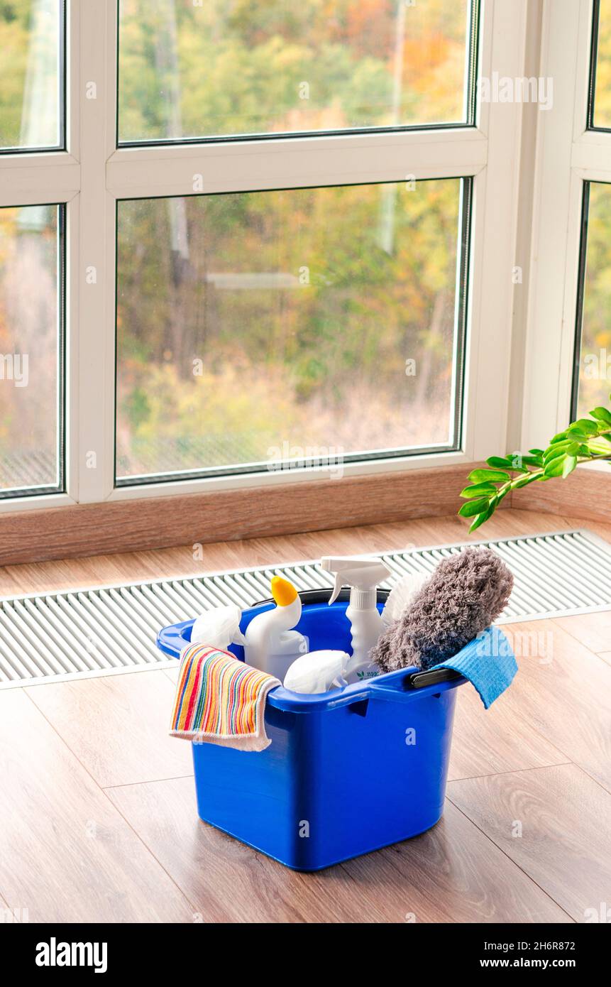 Detergente per la casa su pavimento in legno su sfondo finestra Foto Stock