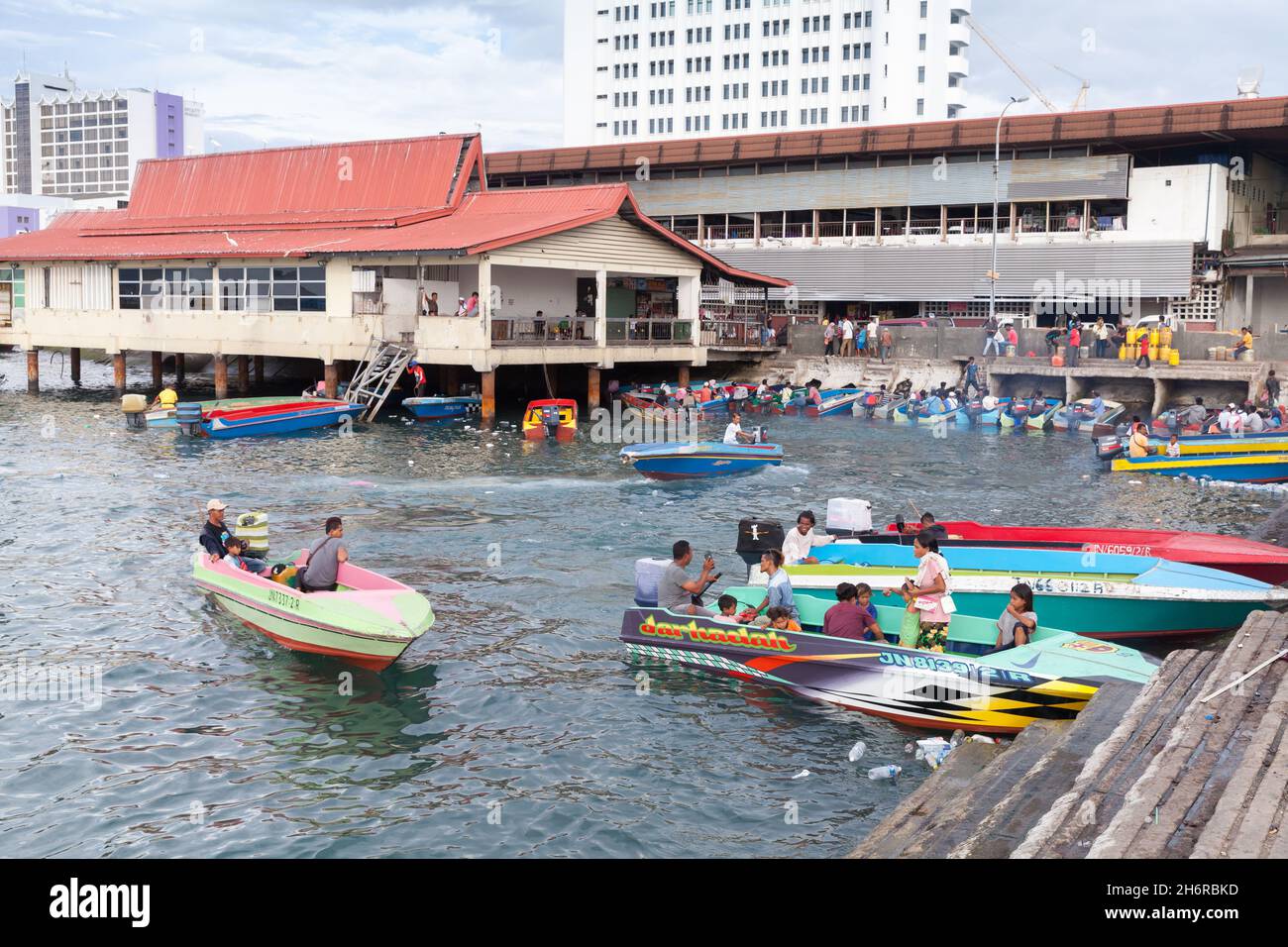 Kota Kinabalu, Malesia - 23 marzo 2019: Barche a motore con passeggeri sono ormeggiati vicino al mercato del pesce KK in una giornata di sole, a buon mercato mezzi pubblici betwee Foto Stock