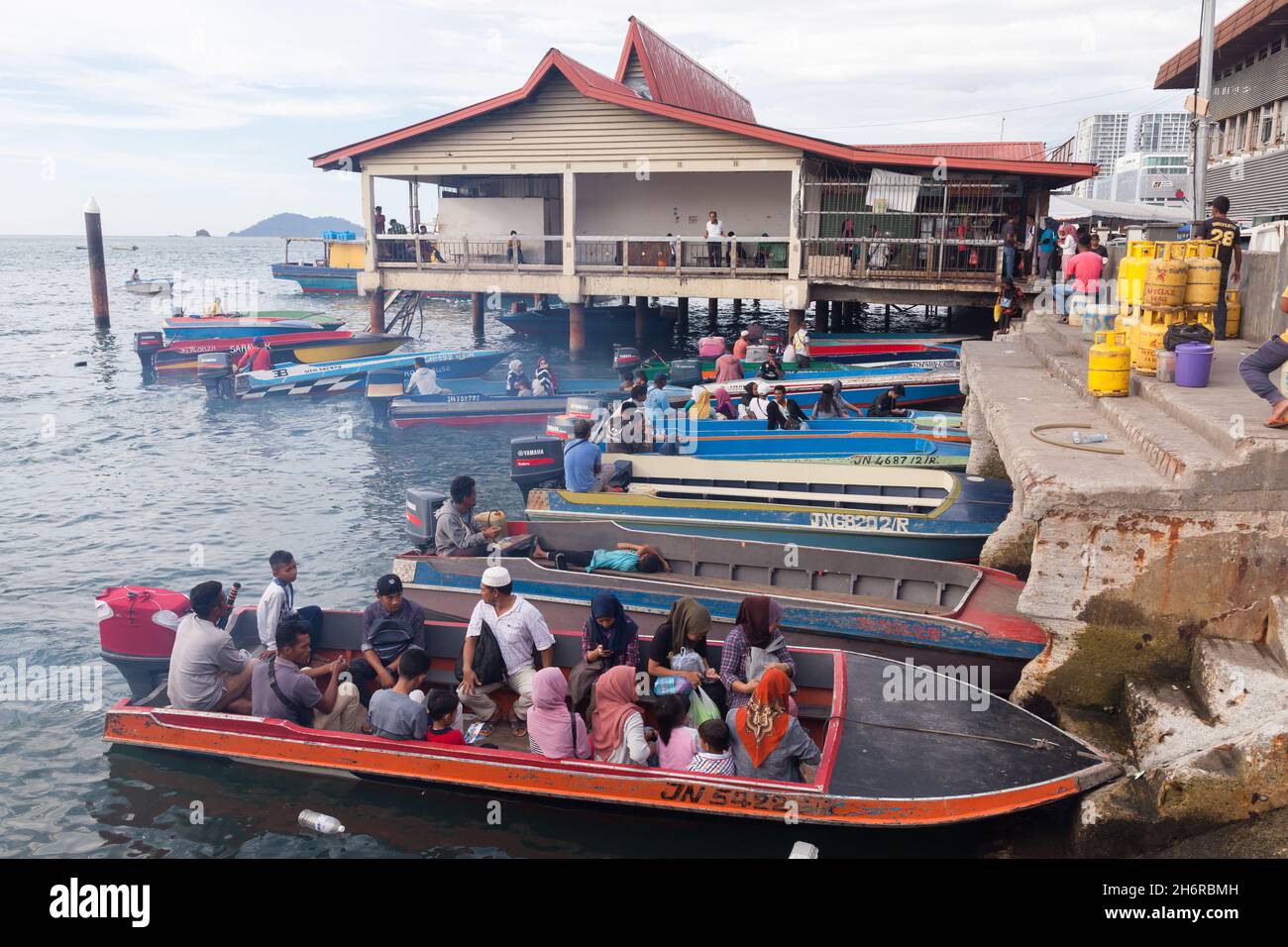Kota Kinabalu, Malesia - 23 marzo 2019: I motoscafi pieni di passeggeri sono ormeggiati dietro il mercato del pesce KK in una giornata di sole, a buon mercato mezzi di trasporto pubblico betwee Foto Stock