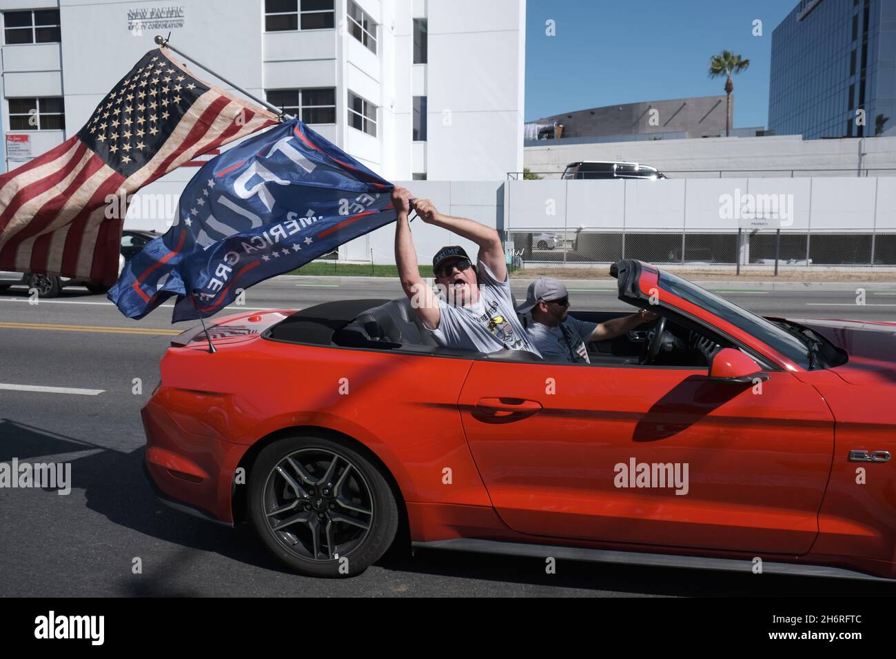 Los Angeles, CA, Stati Uniti. 8 ago 2020. Un uomo ondeggia una bandiera americana e una bandiera pro-Trump da un convertibile in un raduno settimanale a Los Angeles. Credit: Rise Images/Alamy Foto Stock