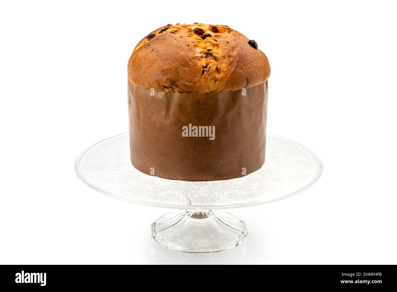 Panettone - torta di Natale italiana di Milano, preparata per festeggiare Natale e Capodanno, su vassoio in vetro rialzato, isolato su bianco Foto Stock