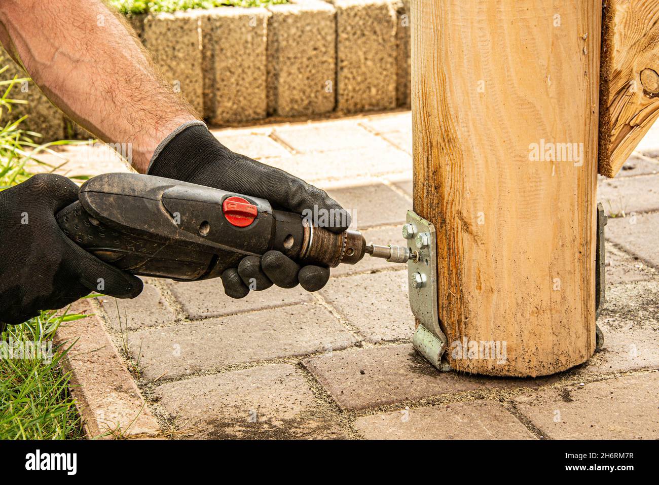 Gli operatori che indossano i guanti devono utilizzare un cacciavite elettrico per serrare la vite. Foto Stock