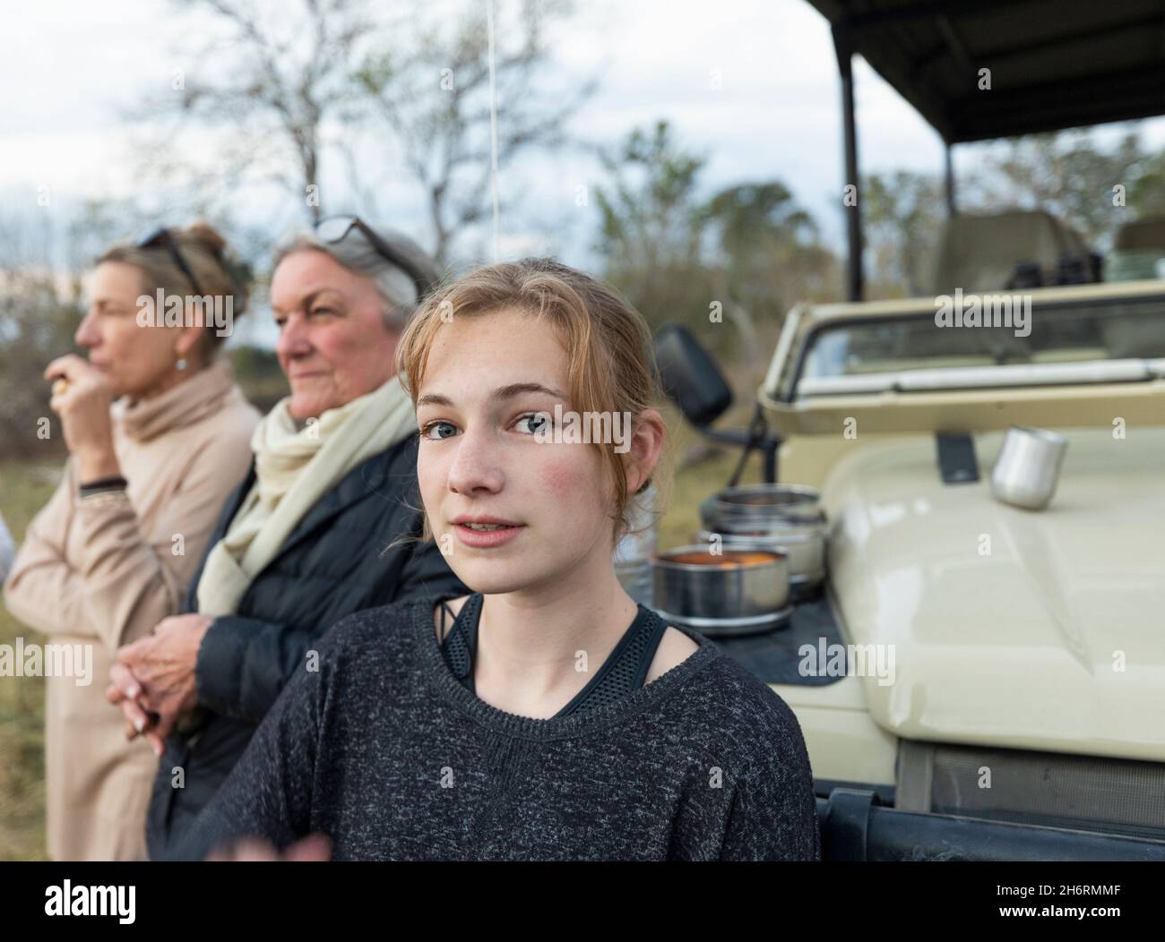 Tre generazioni di donne, una nonna, una madre e una ragazza adolescente da una jeep safari Foto Stock