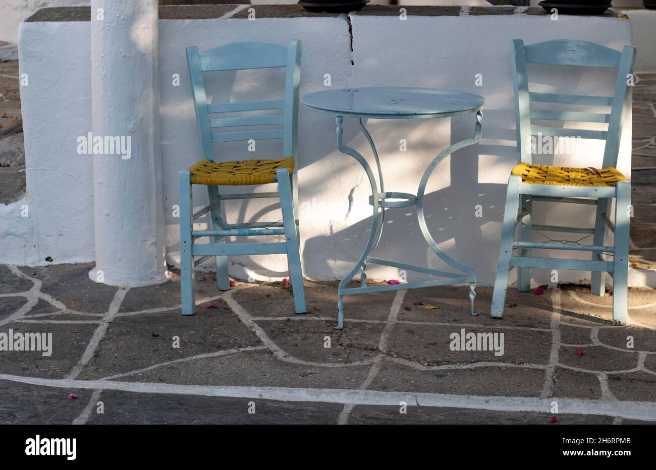 Bellissima isola di Folegandros, Grecia. Taverna tradizionale tavoli e sedie sulla piazza del paese. Scena greca tipica. Visualizzazione orizzontale. Foto Stock