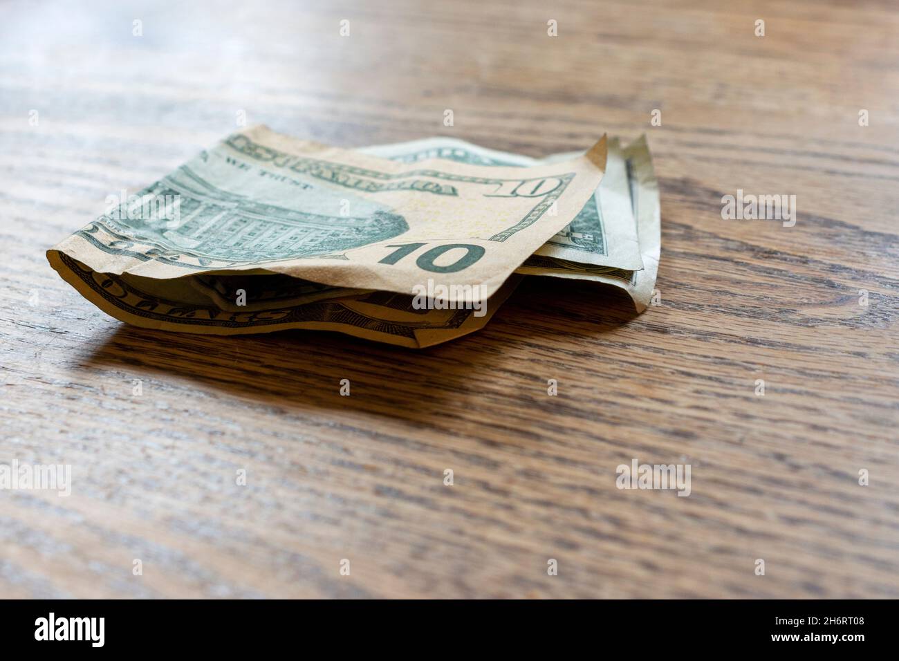 $10 e $1 di soldi degli Stati Uniti siede su un tavolo di legno. Foto Stock
