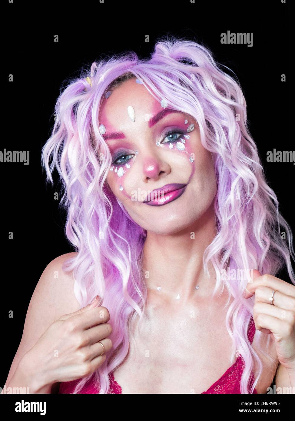 Ragazza con trucco brillante e capelli viola Foto Stock