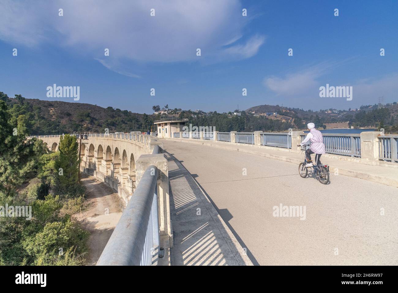 Los Angeles, CA, USA - November17, 2021: Un bicyclist attraversa il lago Hollywood attraverso la diga di Mulholland a Los Angeles, CA. Foto Stock