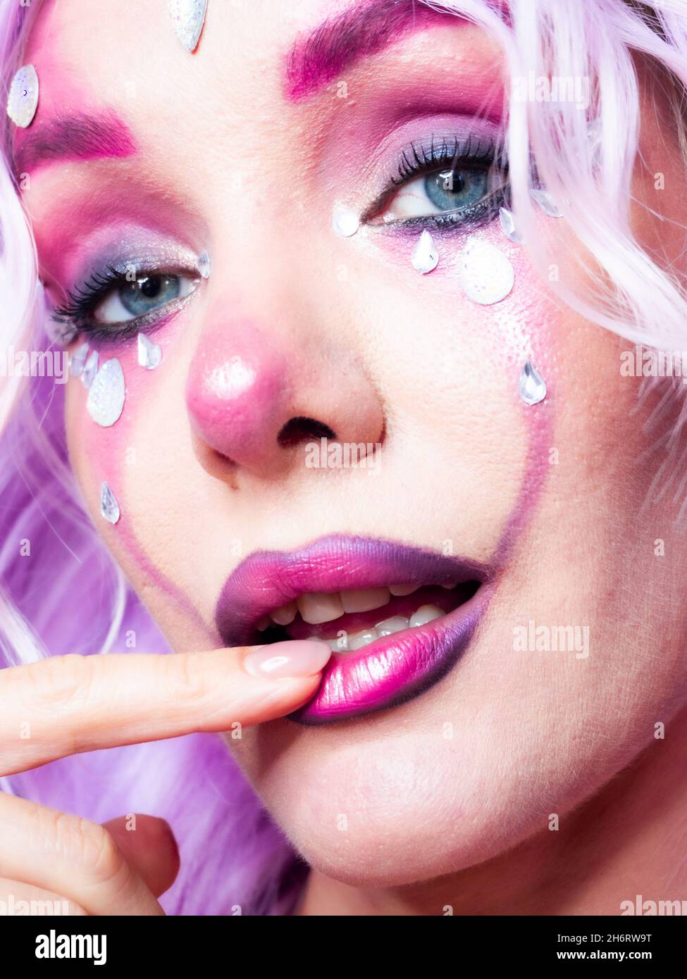 Ragazza con trucco brillante e capelli viola Foto Stock