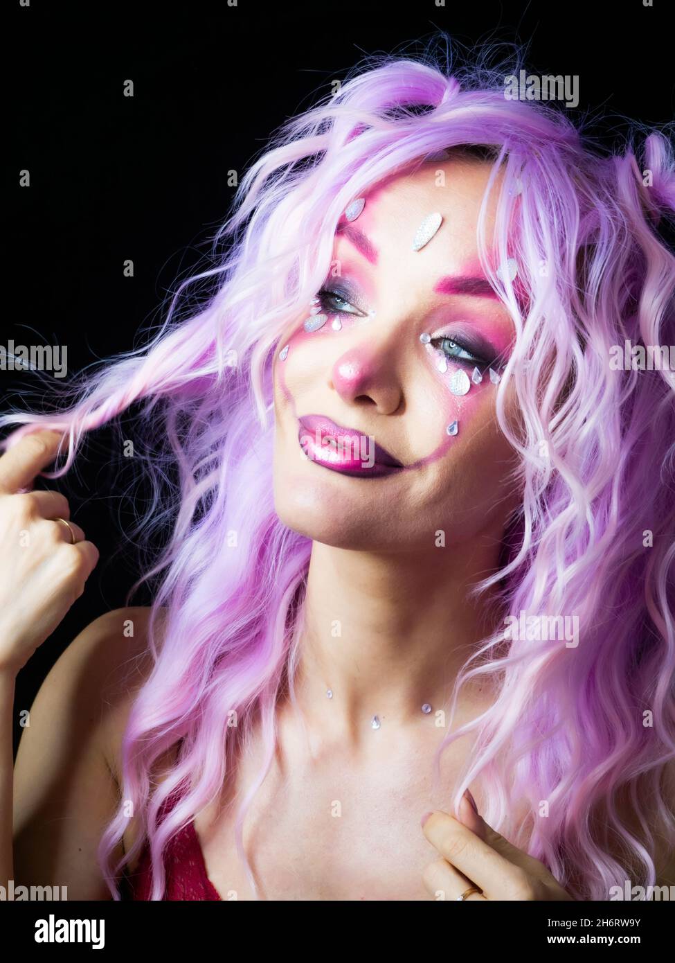 Ragazza con trucco brillante e capelli viola Foto Stock