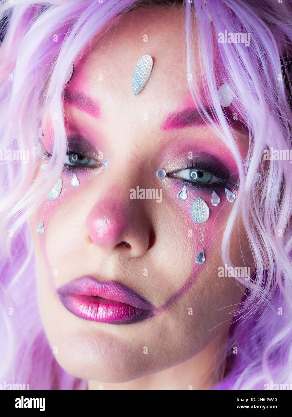 Ragazza con trucco brillante e capelli viola Foto Stock