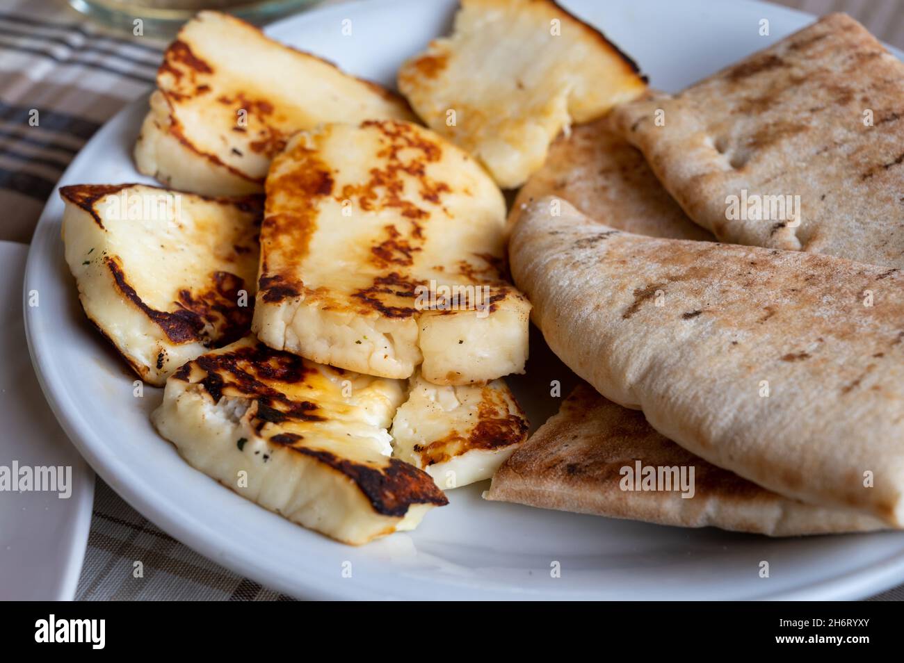 Tradizionale formaggio halloumi arrostito o alla griglia di Cipro servito caldo con pane greco piatto Foto Stock