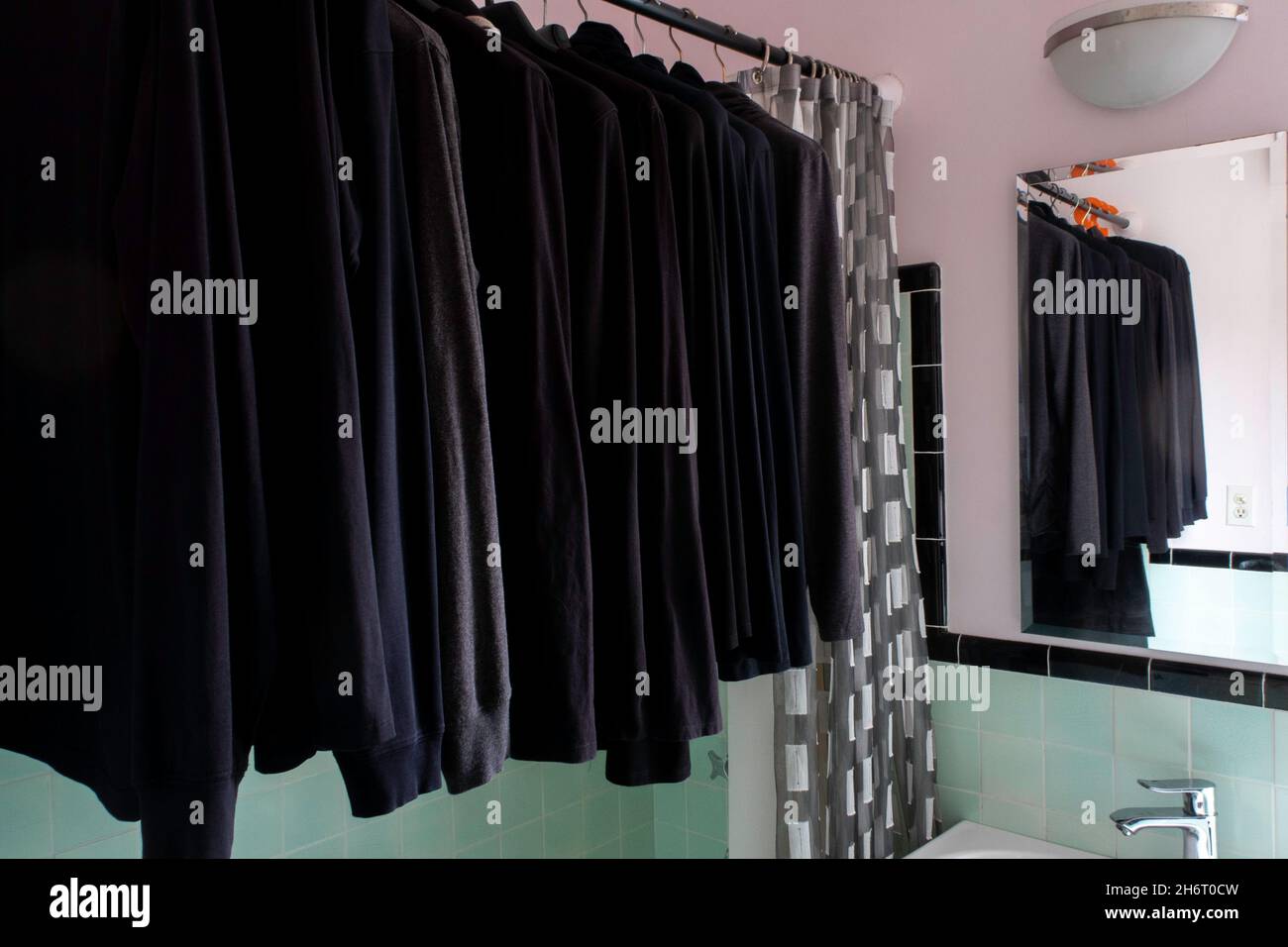 Tutto il guardaroba nero appeso in un bagno di appartamento di NYC, Stati Uniti, 2021 Foto Stock