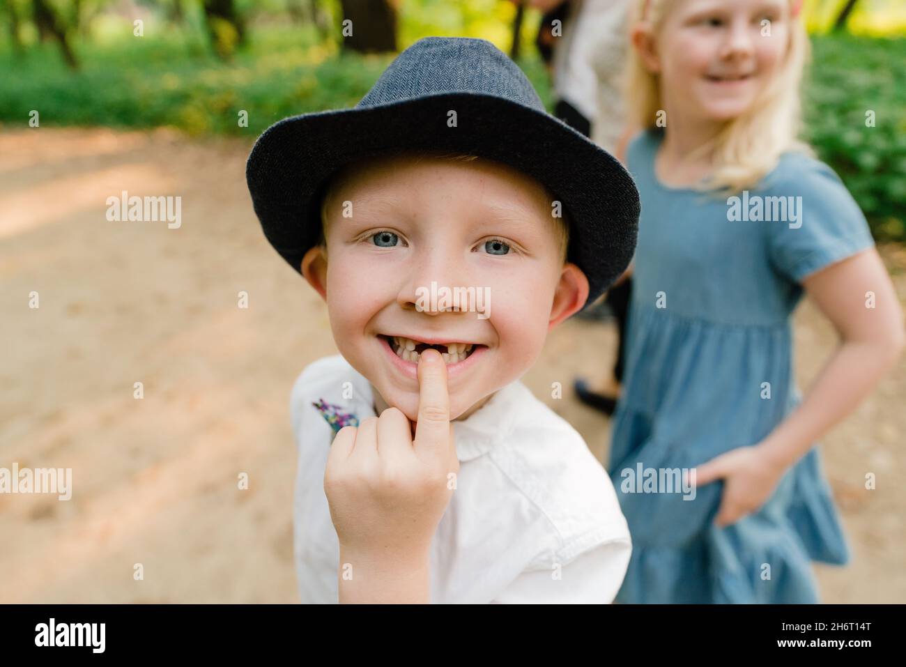 Primo piano di un ragazzo che punta al gap nei denti anteriori Foto Stock