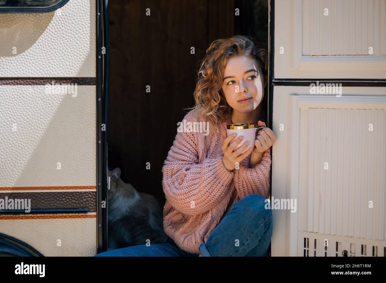 Donna che beve caffè con gatto in porta di rimorchio, spazio copia. Foto Stock