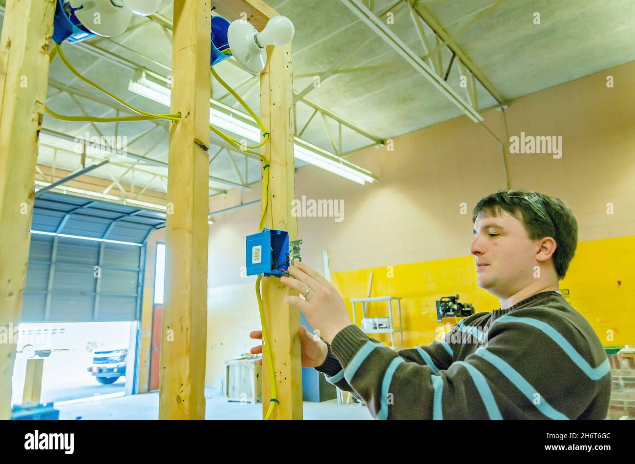 Un insegnante del negozio della scuola superiore mostra agli studenti come installare un interruttore luce, 24 gennaio 2013, a Columbus, Mississippi. Foto Stock