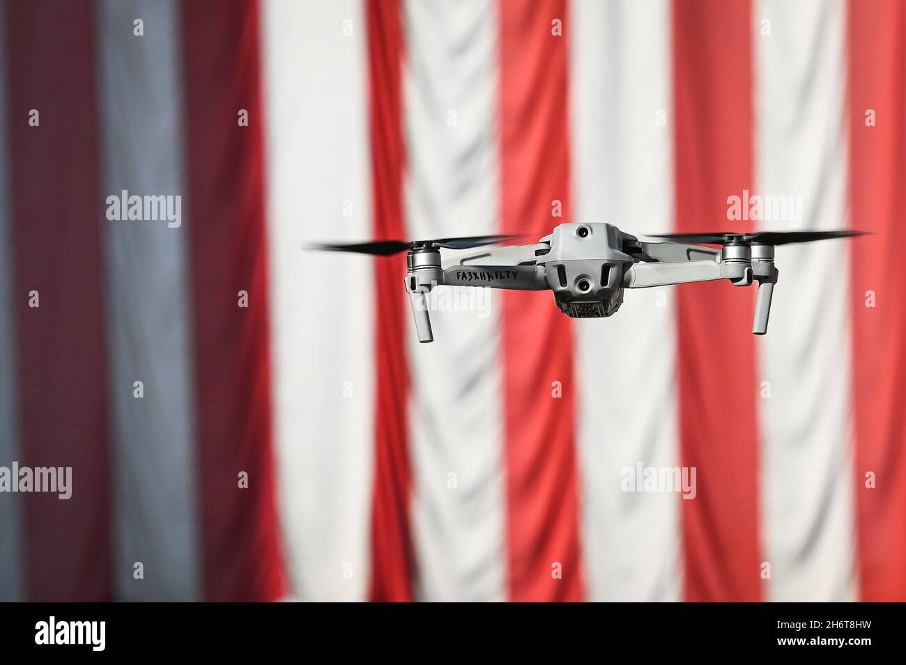 Un drone vola di fronte a una grande bandiera americana sulla Main Street a barre, VT, USA, il giorno dei Veterans. Foto Stock