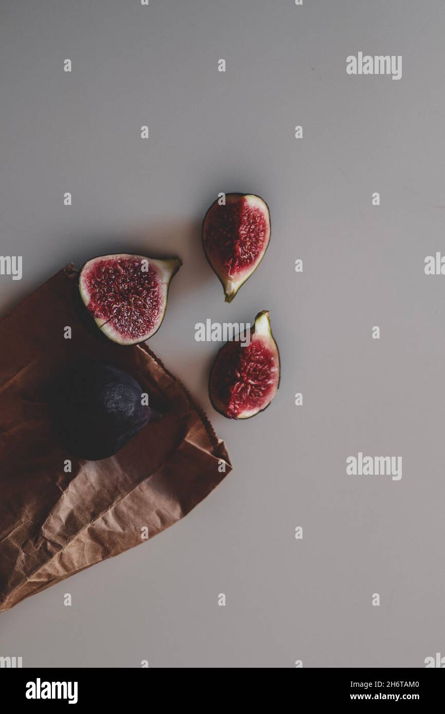 Raccolta di frutta fresca di fichi maturi interi e dimezzati, sulla carta artigianale marrone. Cibo biologico. Minimalismo, spazio di copia Foto Stock