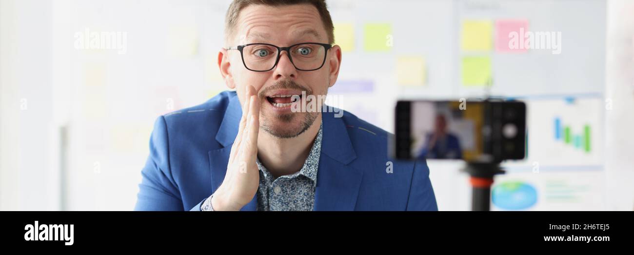 Il coach maschile racconta i segreti del business di successo alla macchina fotografica Foto Stock