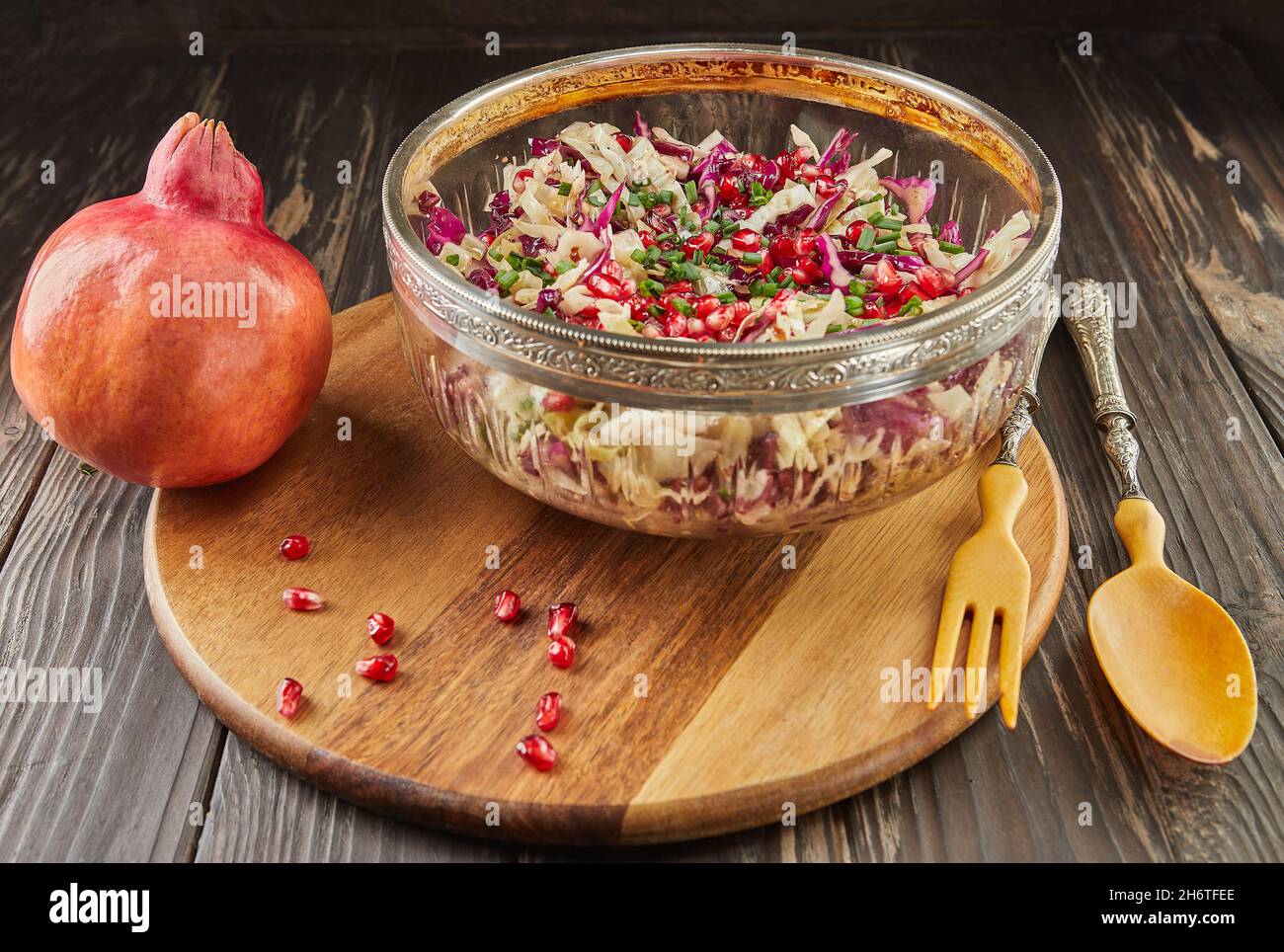 Insalata di cavolo di due colori con semi di melograno, melograno e noci salate. Cucina gourmet francese. Foto Stock