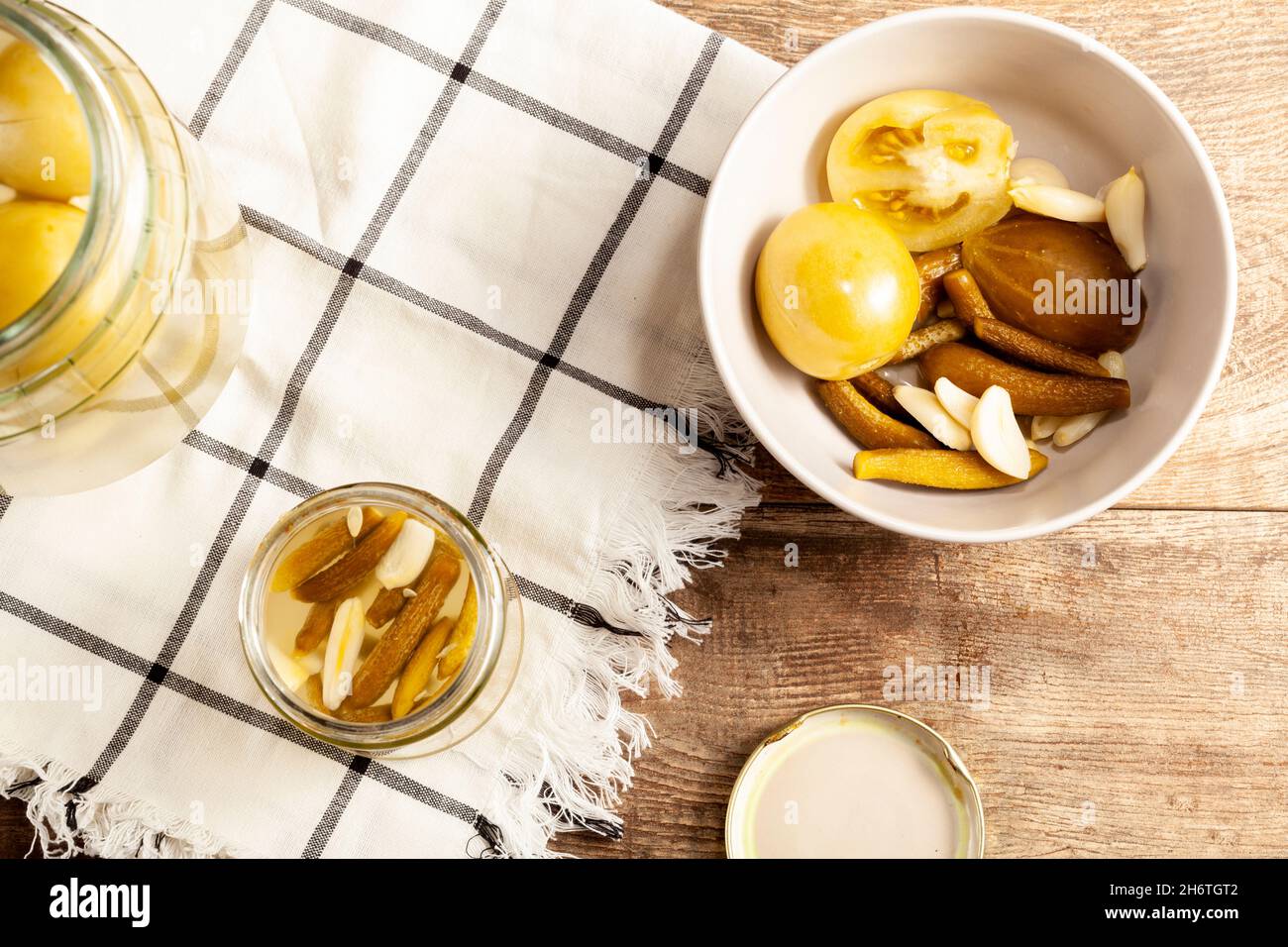 Immagine piatta che mostra una ciotola con zucca sottaceto e pomodori. Immagine concettuale per decapaggio, probiotici, cibo delizioso e sano Foto Stock