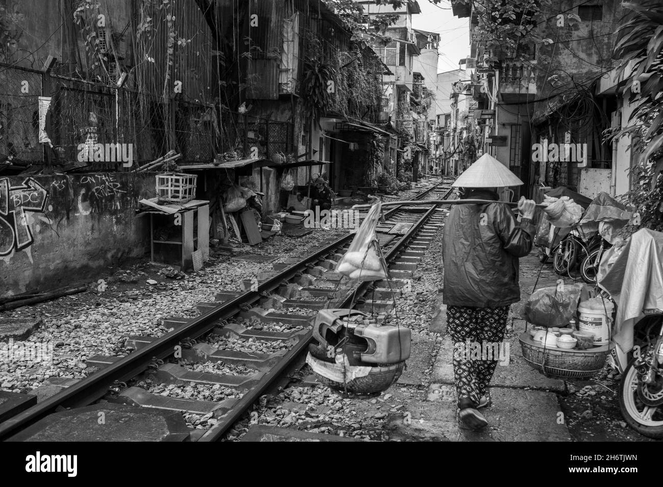 Una strada ha una linea ferroviaria che corre nel mezzo e ogni giorno su questa strada le attività della gente continuano come al solito. È anche noto come tr Foto Stock