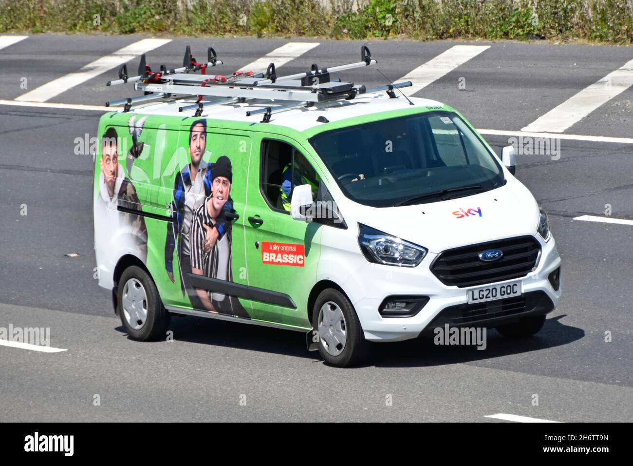 Vista laterale e frontale Sky TV ingegnere in bianco Ford Transit van green grafica pubblicità il Brassic British commedia televisione show guida autostrada UK Foto Stock