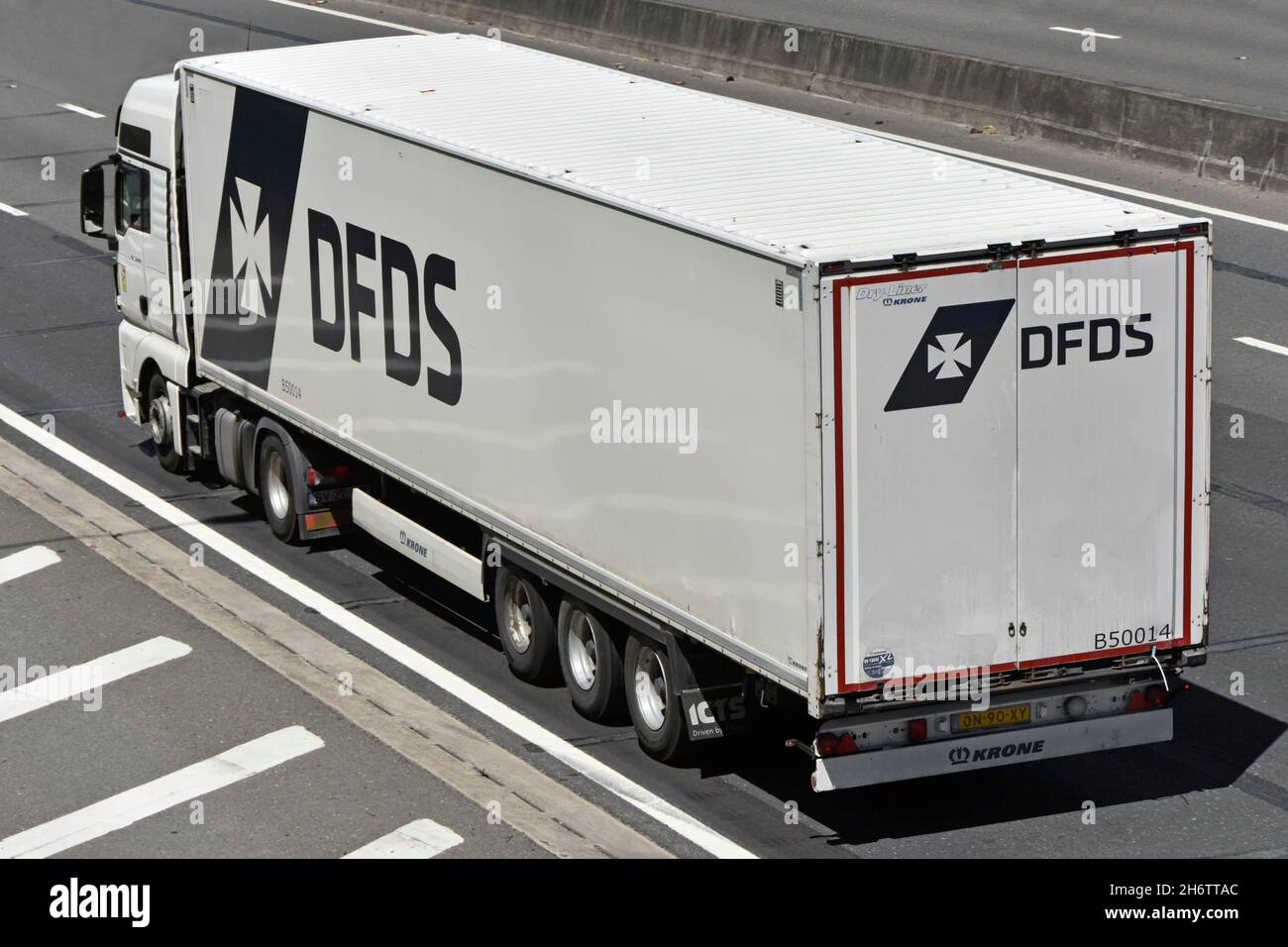 Vista laterale posteriore e aerea del logo DFDS bianco Danish International Shipping Logistics business hgv camion rimorchio articolato guida autostrada UK Foto Stock
