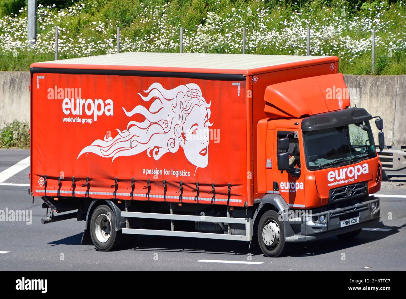 Accesso laterale a tendina e vista frontale arancione europa European Road carry business marchio logo pubblicità grafica camion guida su autostrada UK Foto Stock