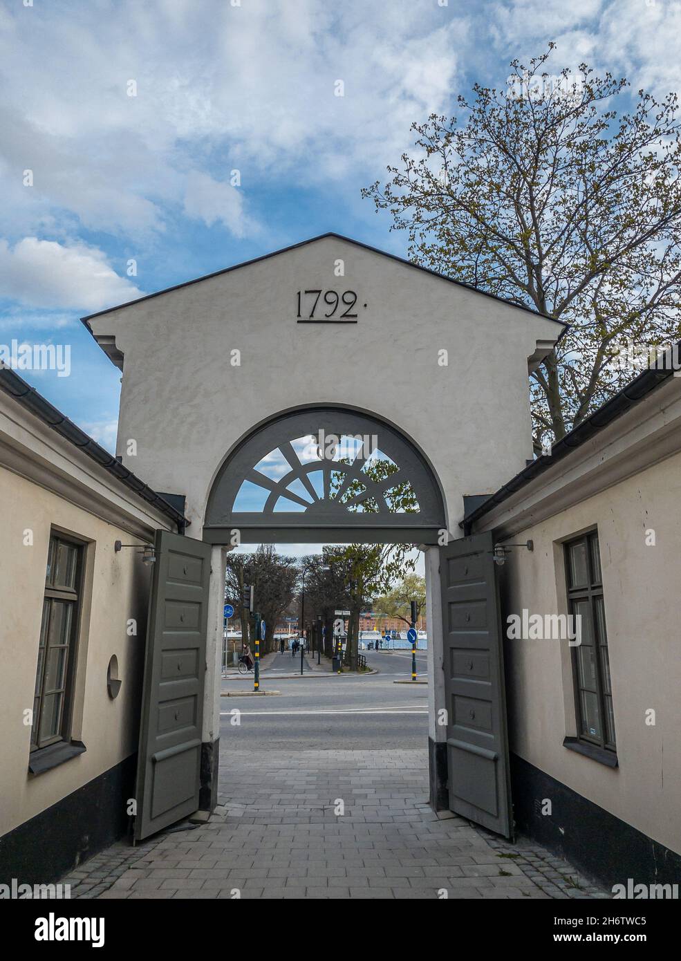 Stoccolma, Svezia - 28 aprile 2021: Uno storico ingresso ad arco, costruito nel 1792, con porte aperte che conducono alla strada vicino al municipio di Stoccolma Foto Stock