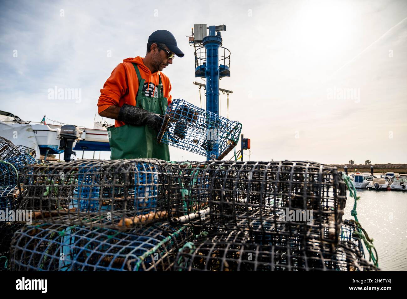 Alvor, Portogallo - 28 ottobre 2021: Un uomo che si prende cura delle attrezzature per la cattura dei polpi Foto Stock