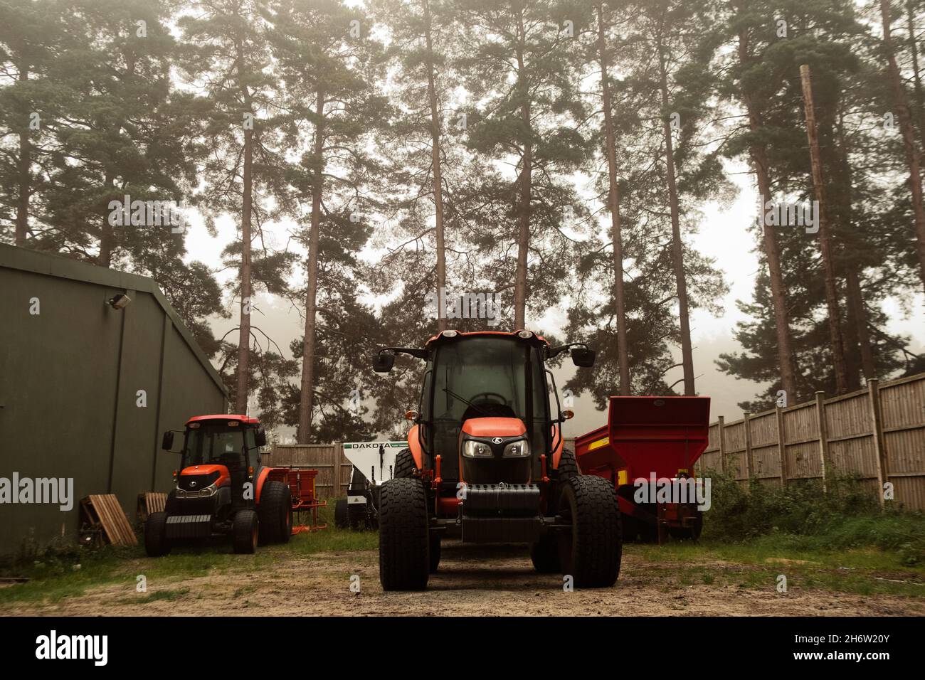 Trattore e attrezzature per la manutenzione in un bosco al Sunningdale Golf Course, Ascot, Berkshire, Inghilterra, Regno Unito Foto Stock