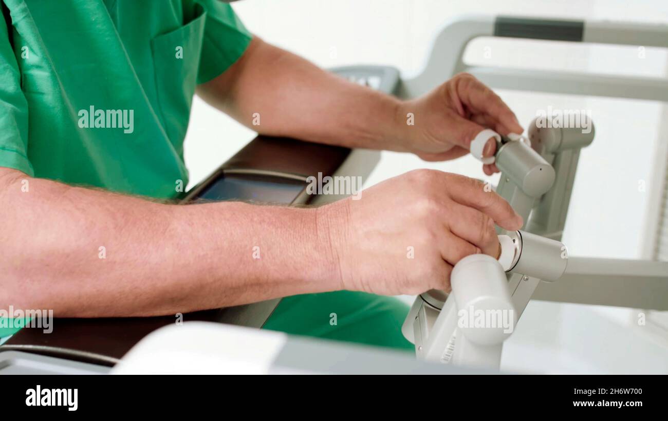 primo piano di un medico o di un chirurgo che manipola un robot chirurgico, per eseguire le operazioni Foto Stock
