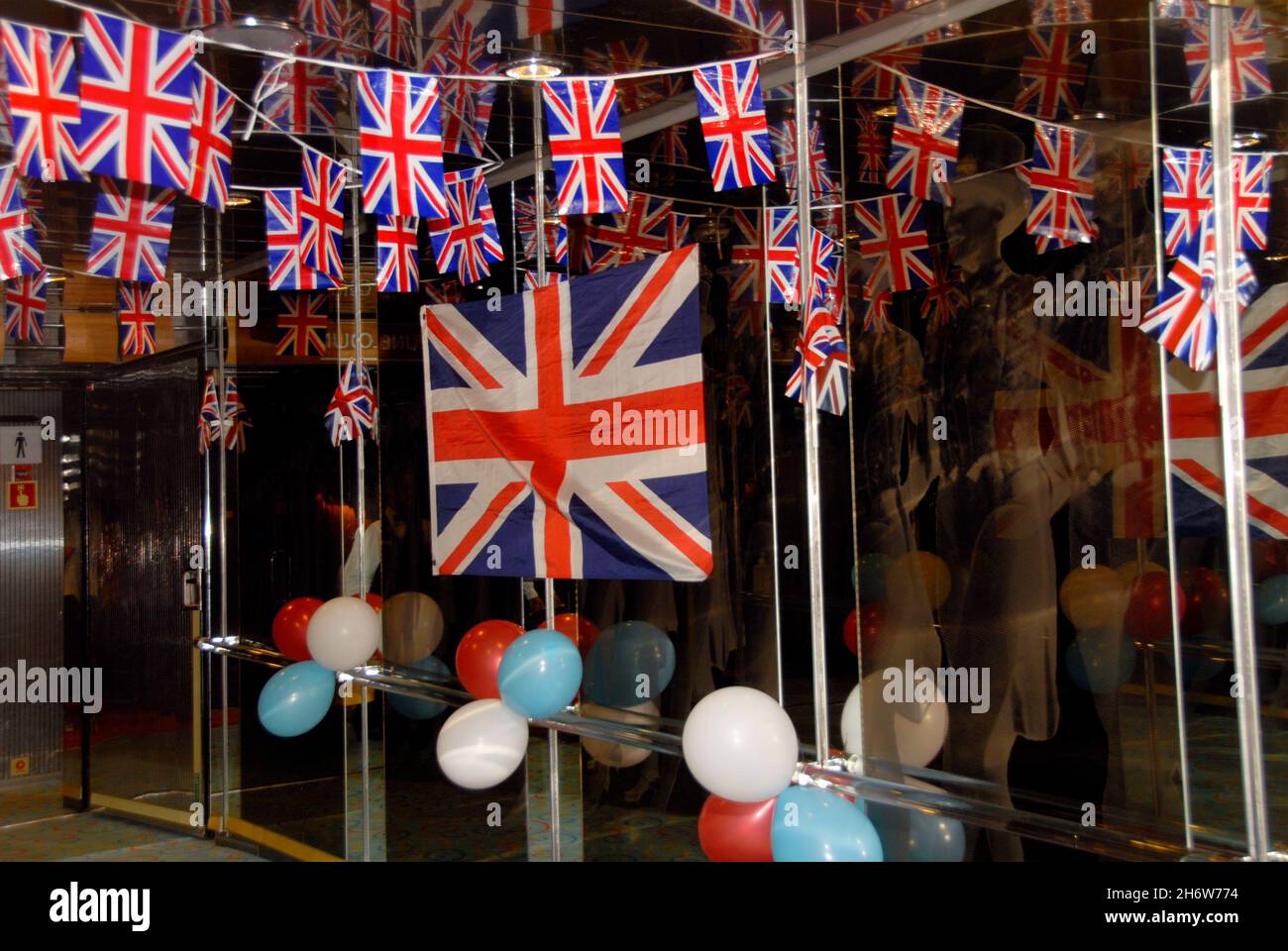 Bandiere Union e palloncini rossi, bianchi e blu in mostra all'interno di un battello da crociera per accogliere gli ospiti per un intrattenimento serale con sede nel Regno Unito Foto Stock