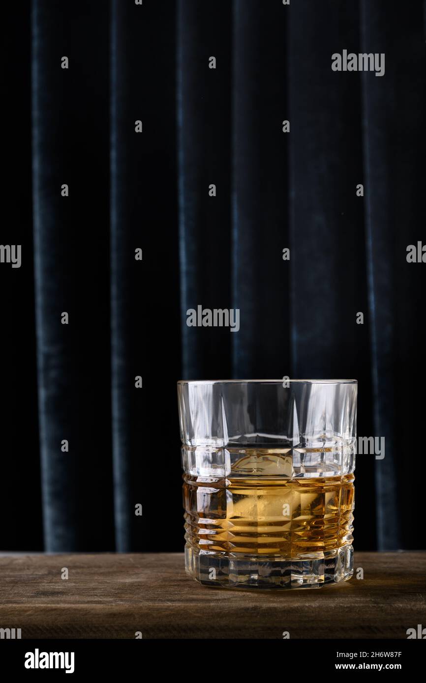 Whiskey freddo servito in rocce su una tenda blu scuro sfondo alla moda. Formato verticale. Primo piano. Spazio di copia. Foto Stock