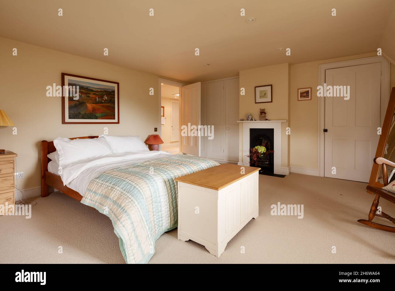 Wimbish, Inghilterra - Luglio 30 2019: Camera da letto in casa d'epoca inglese con arredamento tradizionale grande letto e camino. Foto Stock