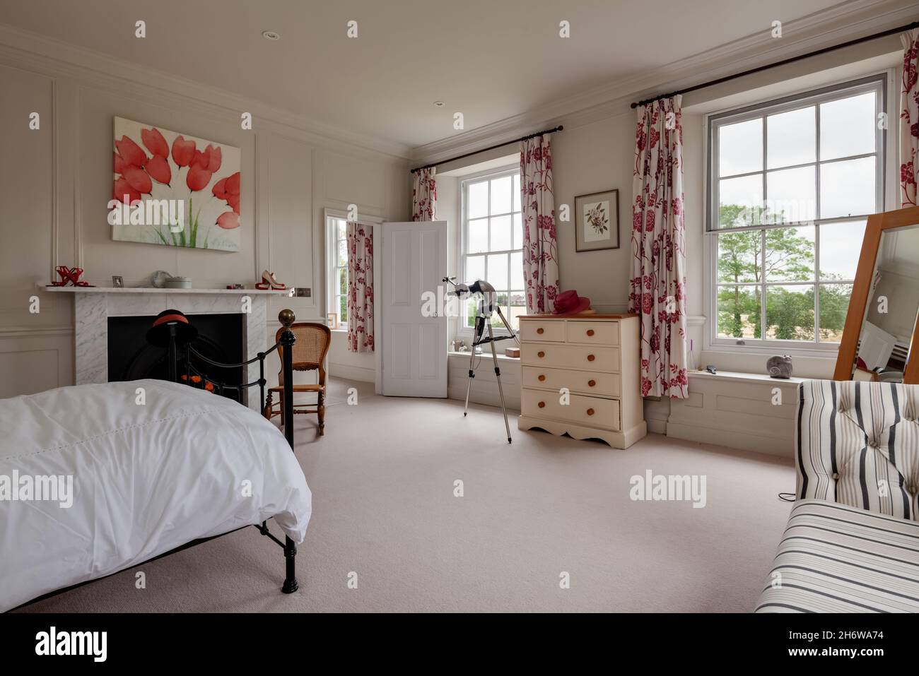 Wimbish, Inghilterra - Luglio 30 2019: Camera da letto in casa d'epoca inglese con arredamento tradizionale ma allo stesso tempo moderno, camino con cornice di marmo Foto Stock