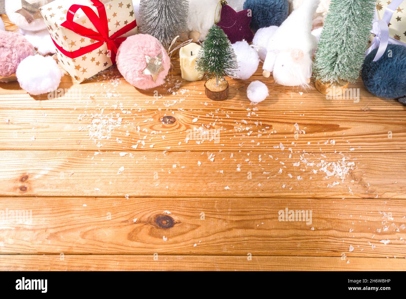Soffice concetto di Natale. Sfondo natalizio con decorazione soffice, palla di Natale, scatole regalo, con neve artificiale su un accogliente tavolo in legno Foto Stock